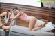 A woman in a pink bathing suit laying on a couch.