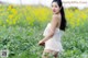 A woman in a white dress standing in a field of flowers.