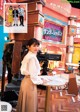 A woman standing in front of a table in a room.