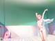 A woman in a pink bikini dancing in a room.