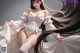 A woman in a white corset and stockings posing for a picture.