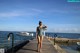 A woman in a bathing suit standing on a dock.