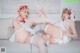 A couple of women sitting on top of a couch.