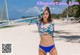 A woman in a bikini standing on a beach.