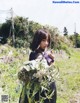 A woman holding a bunch of flowers in a field.