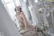 A woman in a white lingerie sitting on a chair.